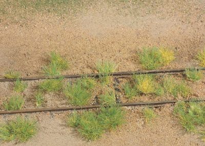 13–Les touffes sont disposées aléatoirement de part et d’autre des rails. Aidez-vous de la photo réelle ci-dessus.