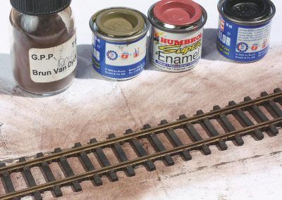 2–La voie qui va recevoir le ballast Décorail, ainsi que le sable et les touffes d’herbe, est préparée : traverses en moins, peinture des rails et des traverses usées auparavant.