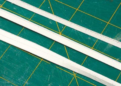 21-Les bandes de papier sont pliées à 90° pour former les côtés de la bordure.