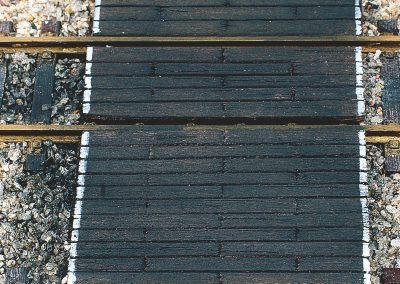 28-Les planches ont reçu une terre à décor noire appliquée à sec qui imite la créosote, produit qui protège le bois du pourrissement. A noter, la peinture en blanc des bords du passage imitant comme dans la réalité les bandes de visibilité.