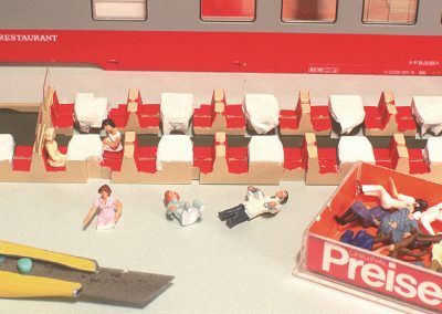 Nous allons maintenant installer des voyageurs à nos tables. Notre choix se fera parmi les personnages assis de la gamme Preiser. Leur mise en place nécessitera quelques «amputations».