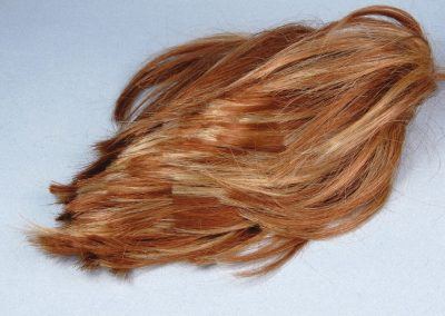 La perruque d'un mélange de blond et d'auburn probablement, convient bien pour l'utilisation prévue. Ses fibres viendront casser la monotonie de la hauteur des autres fibres plus courtes et varier la couleur avec des tonalités plus roussies.