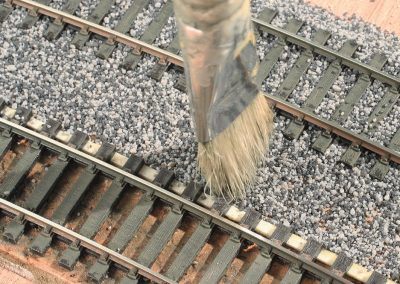 12-La partie centrale entre les deux voies est travaillée de la même façon que les voies. Une fine couche est balayée puis tapotée pour bien répartir le ballast. A gauche la partie mise en forme.