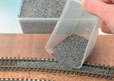 9-Nous avons préféré un mélange de deux ballasts à la couleur opposée plutôt que de poser un granulé monocouleur : affaire de goût. La mesurette à lessive est bien pratique pour déposer le ballast sur la voie.