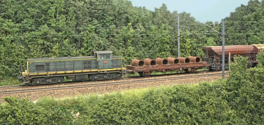 1-Derrière une vénérable BB 63500, deux wagons au chargement original sont placés en tête de rame.