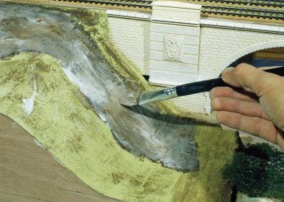 27 - La zone de la prairie est délimitée par la forme peinte en brun sur le talus. Application d’une épaisse couche de vinylique sur cette même surface.