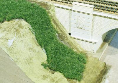 28 - Application de la portion de la prairie sur la colle fraîche. L’extrémité basse de la «prairie» qui sera en contact avec la végétation de la berge est diminuée en hauteur pour mieux se fondre avec les herbes basses de la rive.